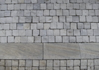 Das Foto zeigt Pflaster aus Laaser Marmor am Bahnhof Laas in Südtirol. Fotografiert im September 2018