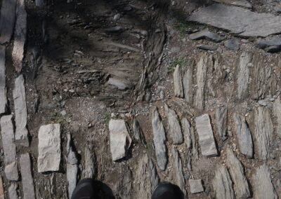 Das Foto zeigt altes Pflster aus brüchigem Lokalgestein mit Reparaturen mit neueren Quarzit-Pflastersteinen auf der Marksburg bei Braubach - fotografiert im Oktober 2024