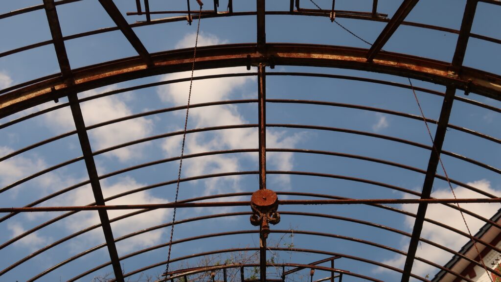 Das Foto zeigt das Eisengerüst der allmählich zerfallenden Orangerie eines Landhauses in der Nähe des S-Bahnhofs Langenberg