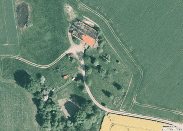 Das Luftbild zeigt die stark beschädigte Scheune des Hofs Obenmetzkes mit dem zu drei Vierteln abgedeckten Dach