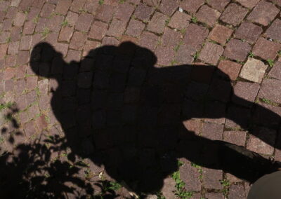 Das Fot zeigt ein Schatten-Selbstporträt auf Straßenpflaster, fotografiert im Juni 2025